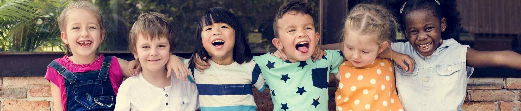 Image of children laughing in a row; courtesy of Shutterstock.